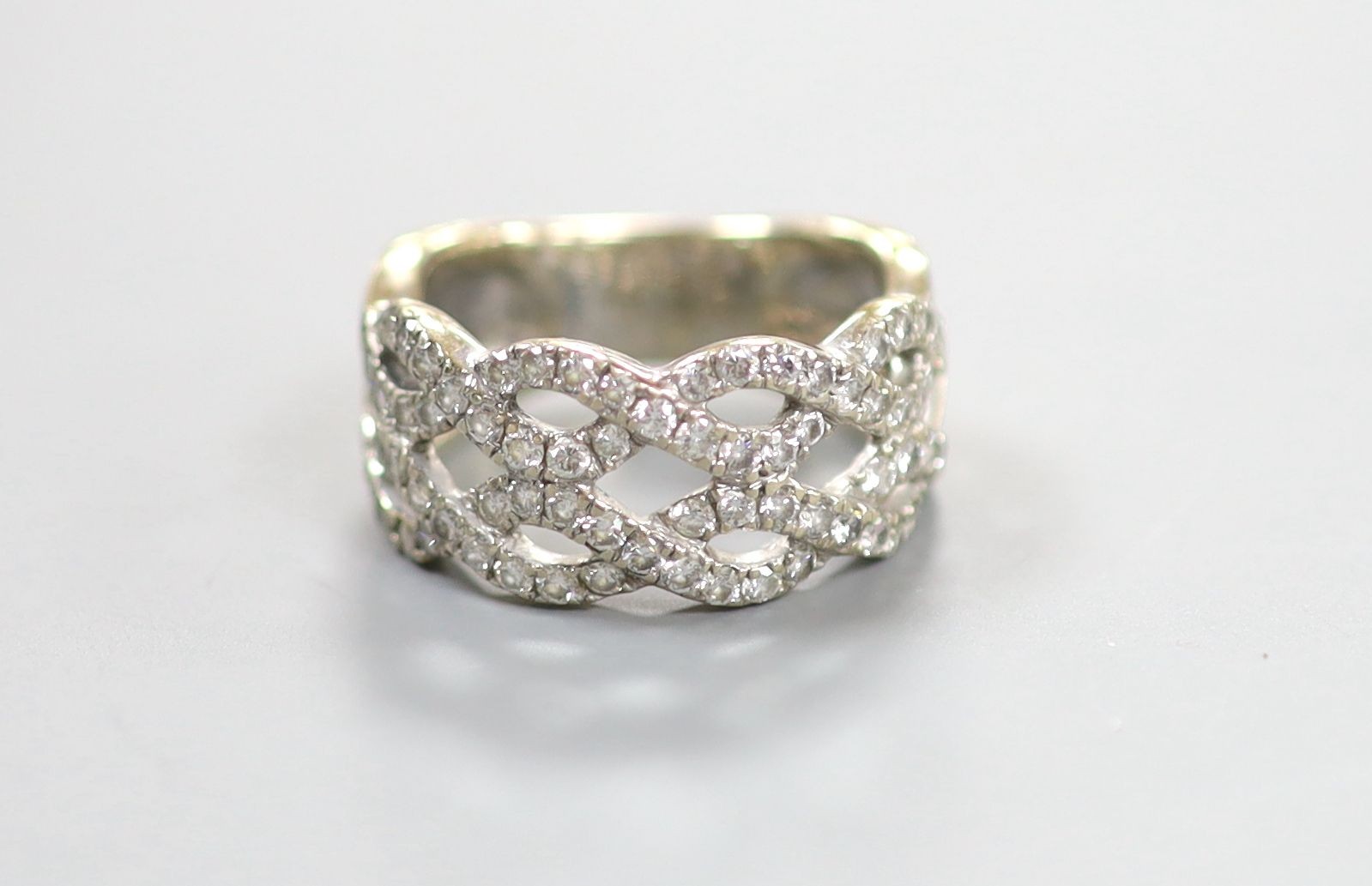 A modern 14k white metal and diamond chip set interwoven dress ring, size M, gross weight 6.5 grams.